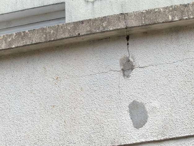 Fissure sous un appui de fenêtre, avec traces de rebouchage