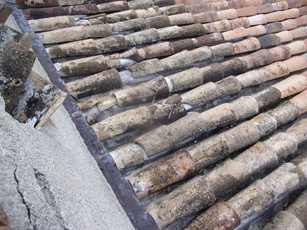 Mur fissuré en rive de toiture, couverture en tuiles canal