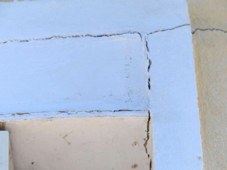 Fissures dans l’enduit à l’angle d’une baie