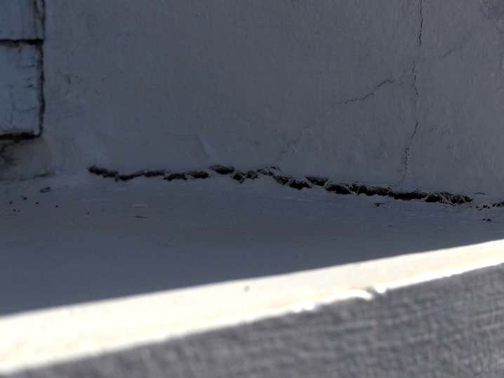 Fissure ouverte au raccord entre un appui et le mur