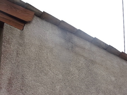 Enduit de façade fissuré sous la rive de toiture