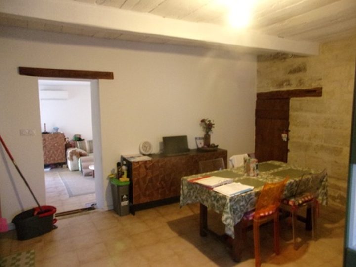 Pièce à vivre de l’appartement expertisé, murs en pierre apparente et poutres